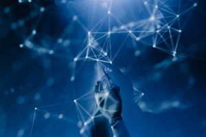 Main robotique touchant un réseau de connexions lumineuses, symbolisant l'intelligence artificielle