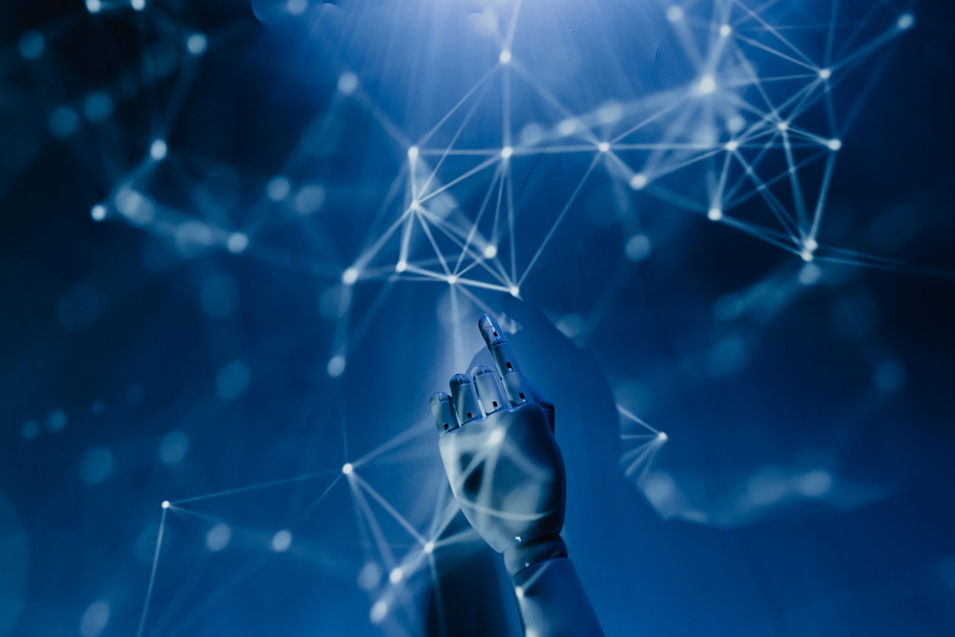 Main robotique touchant un réseau de connexions lumineuses, symbolisant l'intelligence artificielle